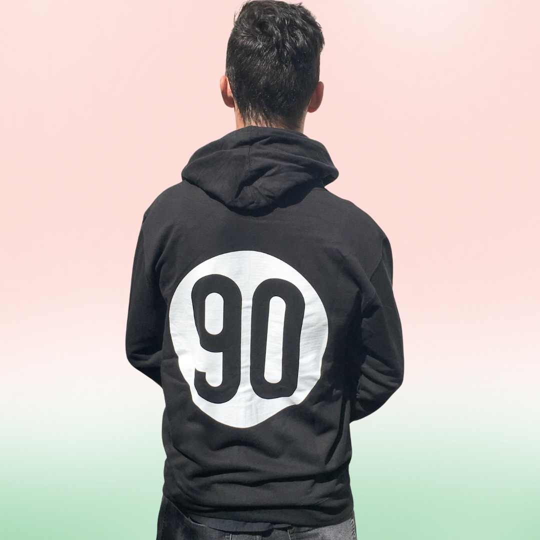 Back view of a man wearing 90 The Original zip hoodie with a prominent '90' logo displayed.