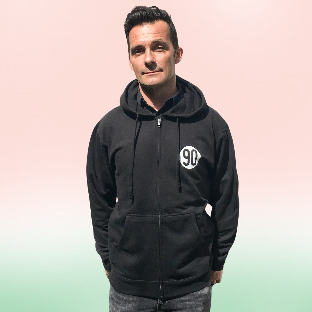 Front view of a man wearing 90 The Original zip hoodie, small '90' logo visible on his right chest.