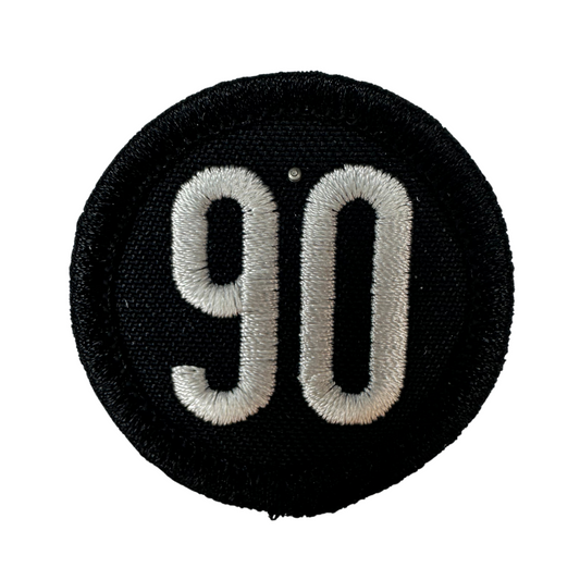 Close-up of the black and silver 90 The Original iron-on patch.
