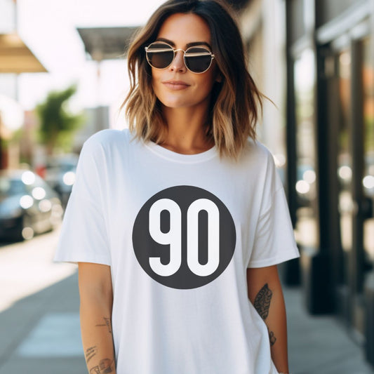 Stylish woman in a classic white 90 The Original tee with a bold logo, perfect for a timeless casual look.